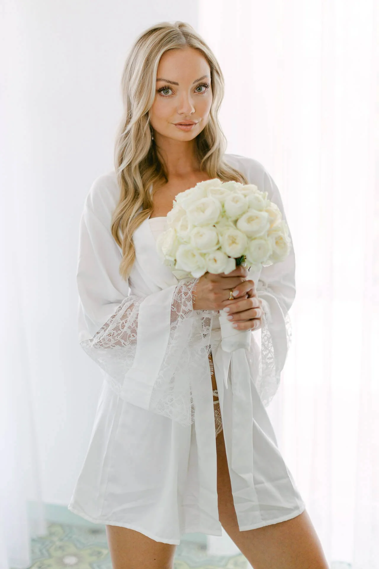 Frau in weißem Kleid mit Blumenstrauß