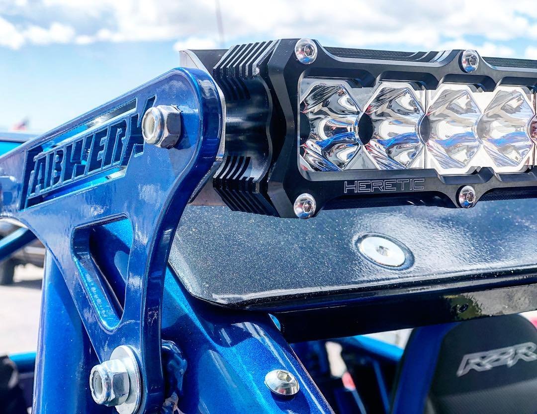 Close-up of a blue Ford racing car with a Heretic LED light bar mounted on the front.