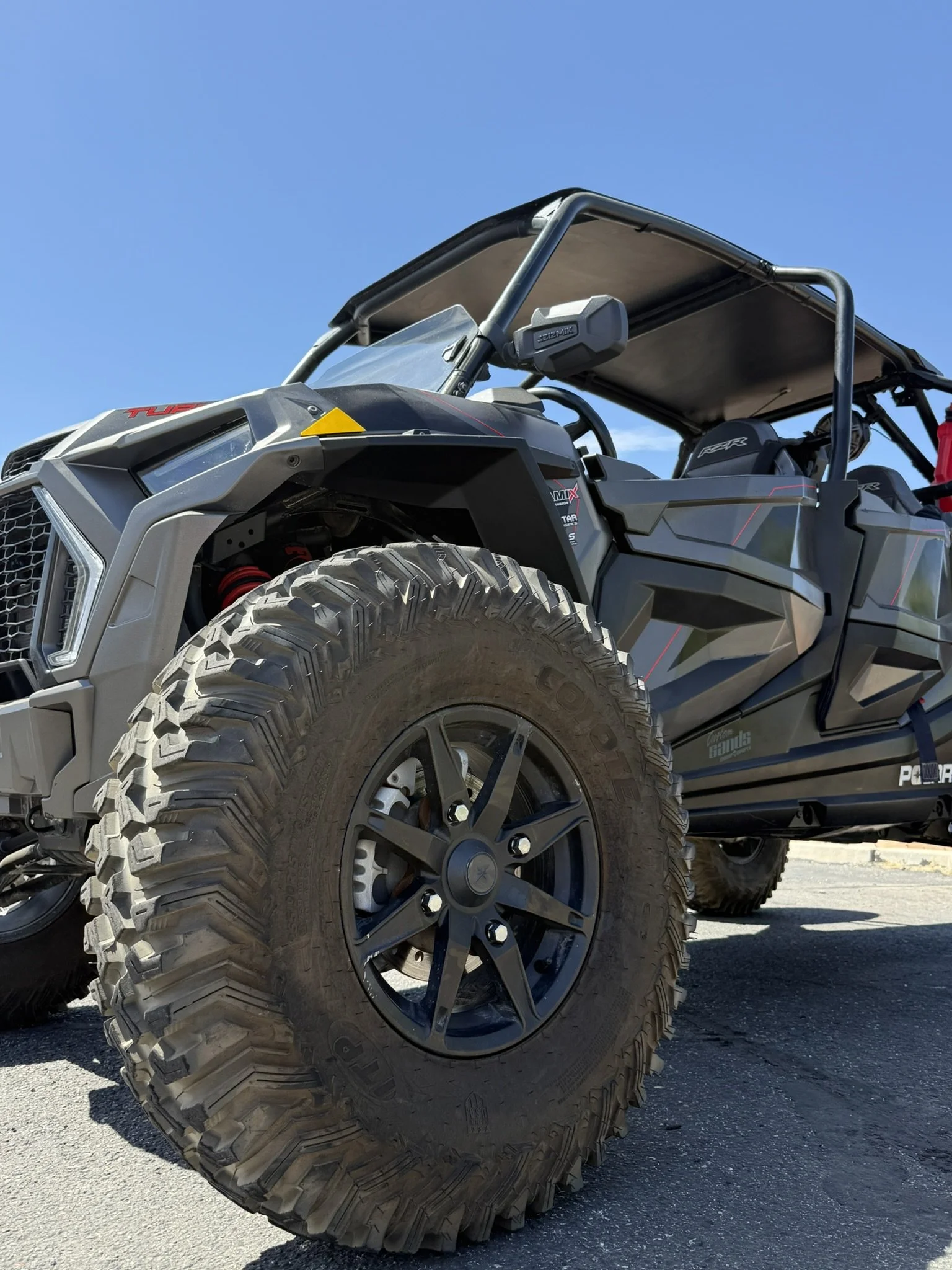 Close-up of a black surface with red and white decal reading 'Custom Shadows motorsports' with a skull logo.