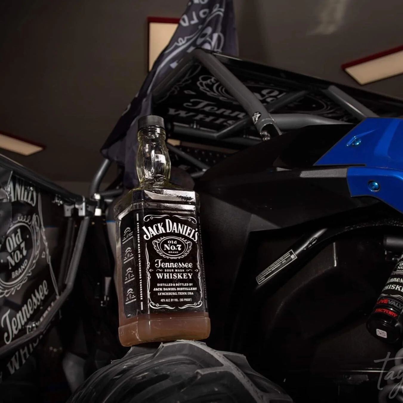 A mini bike with beer bottle stickers, including a Jack Daniel's whiskey bottle sticker attached to it.