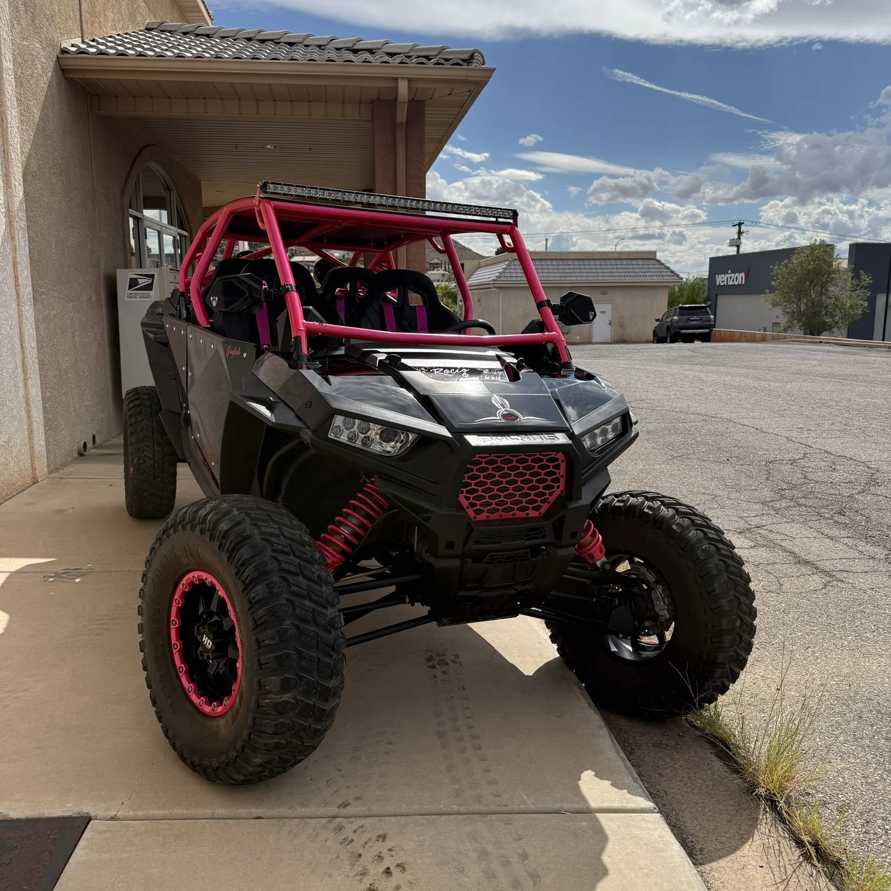 Close-up view of a race car's interior and engine components, featuring a roll cage, a gold-colored honeycomb air vent, and visible suspension parts.