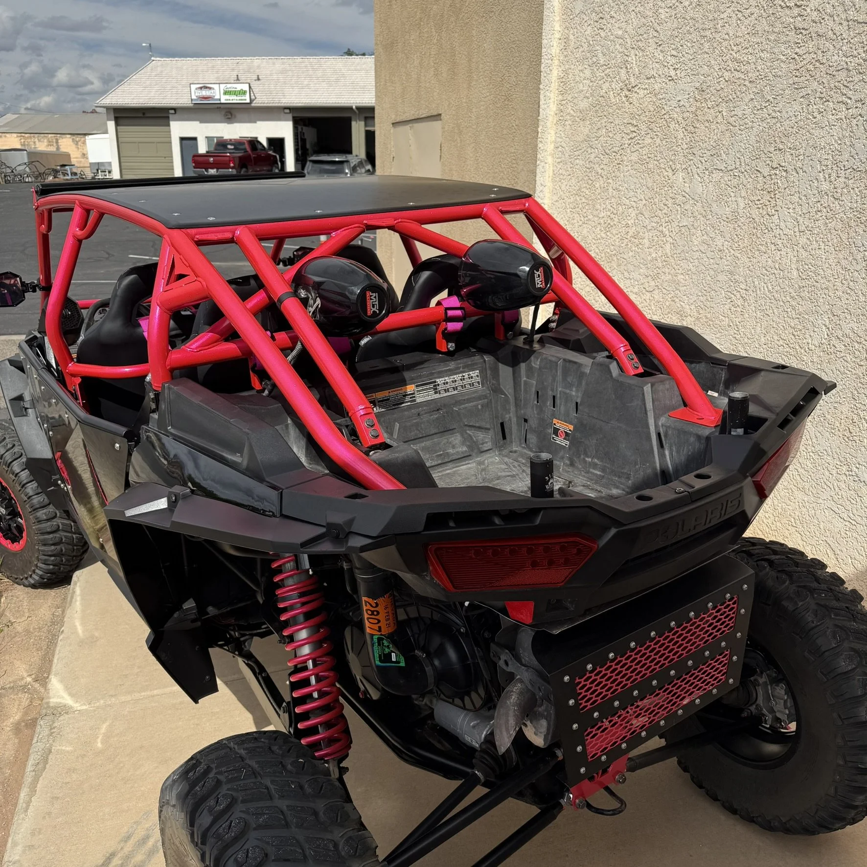 Close-up of a Polaris Turbo S snowmobile rear, featuring gold and black accents with decals that read 'TURBO S' and 'POLARIS', with a suspension and rear wheel visible.