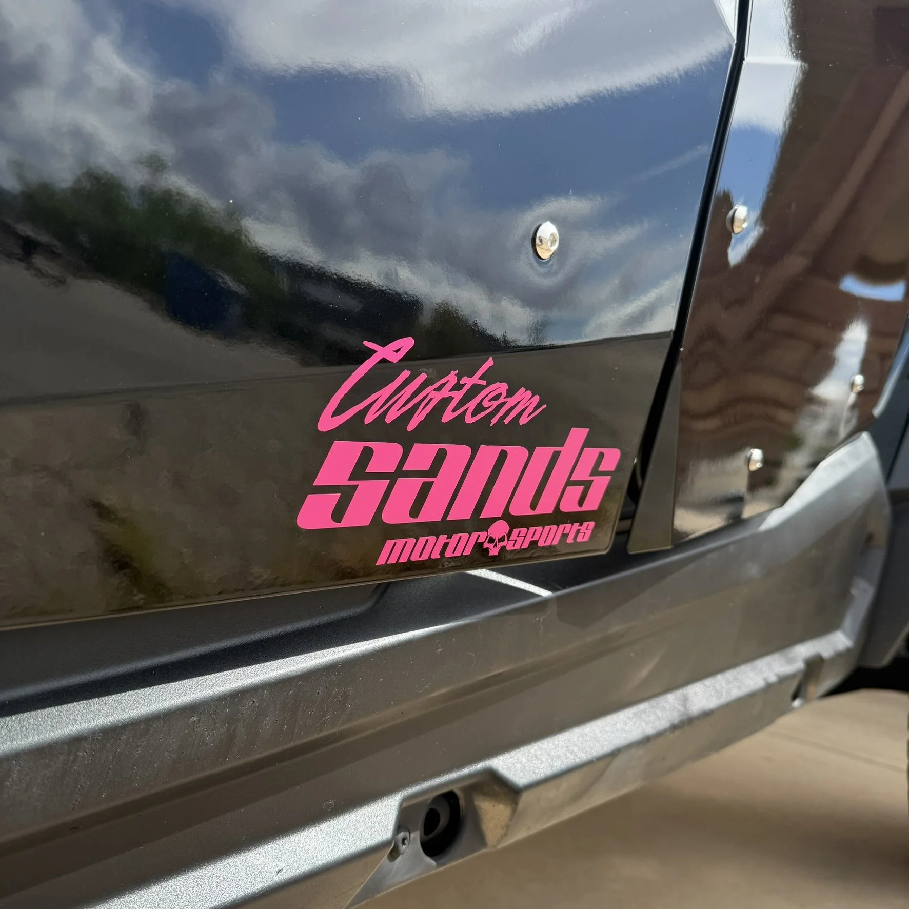 A heavily modified Polaris Slingshot three-wheeled vehicle with black and gold accents, featuring a phoenix decal on the hood, KC off-road lights, and racing seats.