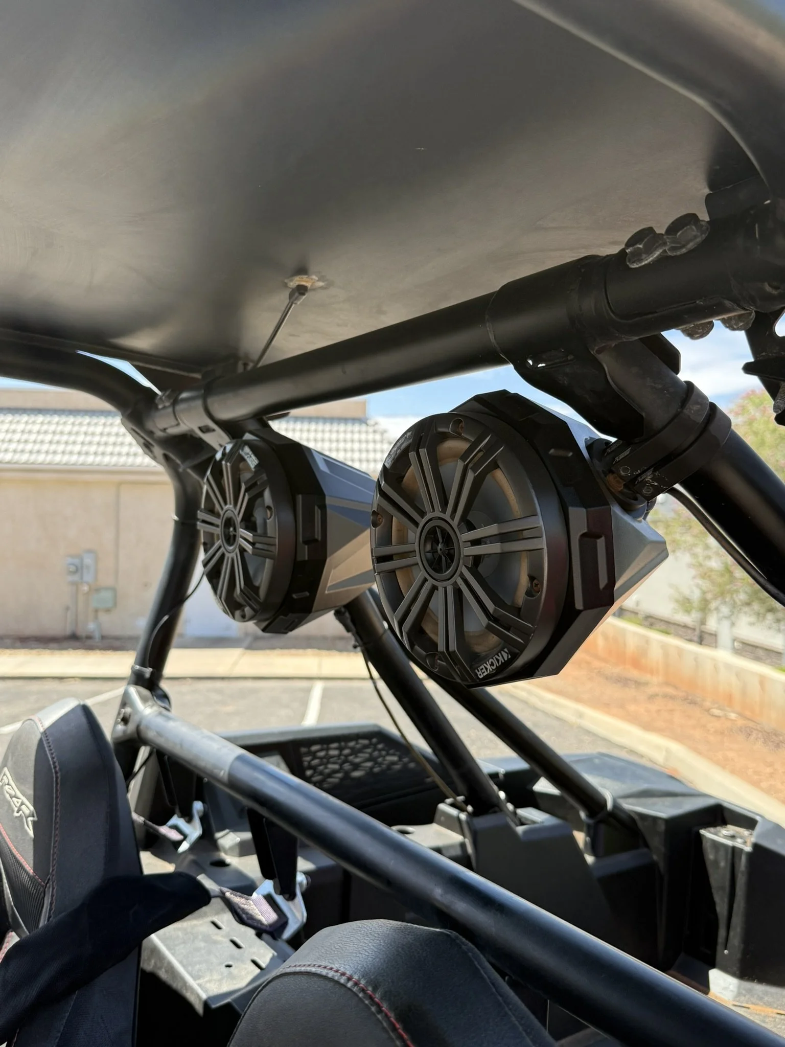 Close-up of a vehicle's rear engine compartment revealing a black BRP logo, shock absorbers, and mechanical components.