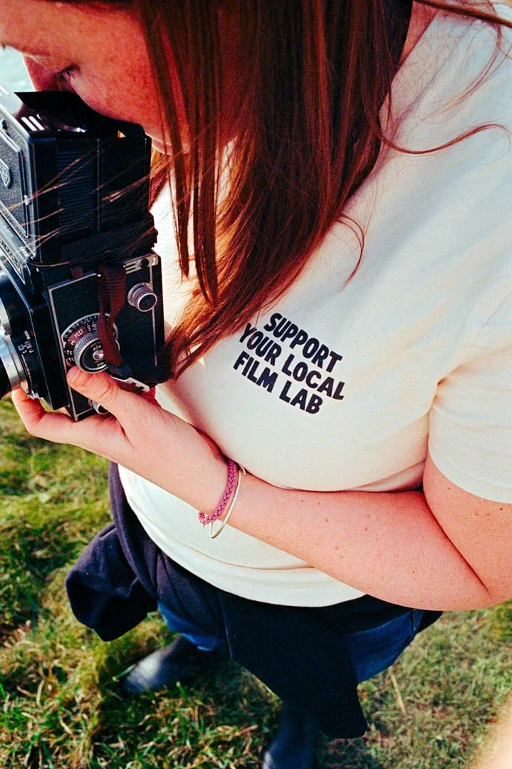 girl with long hair and white t shirt holding rollicord film camera, Kodak ULTRAMAX