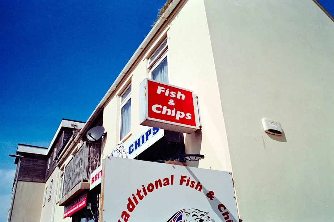 red and white sign above chip shop saying brit chips, canon a-1