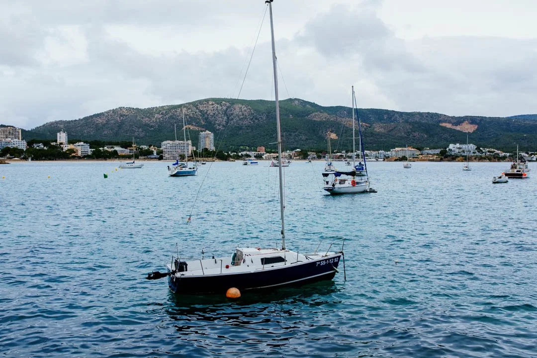 Small yacht on blue water in large harbour Majorca
