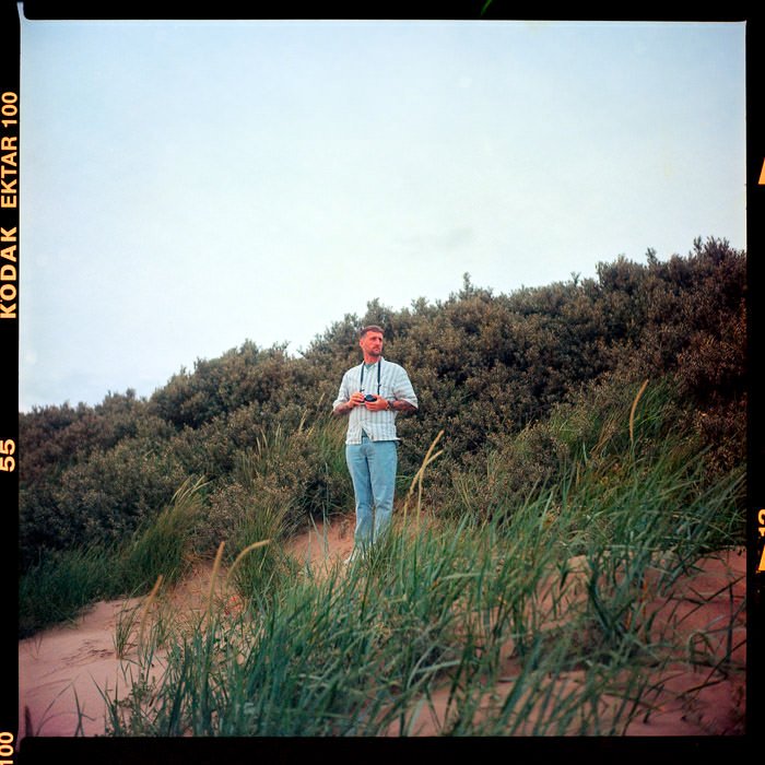 man holding camera stood on large sand dune, Kodak ektar