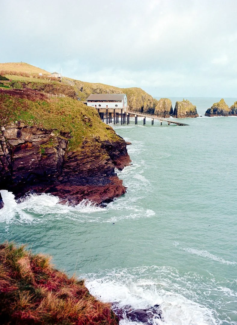 lifeboat station with wooden ramp leading to blue waves ocean, Kodak Portra 160 medium format film, Cornwall coastlne