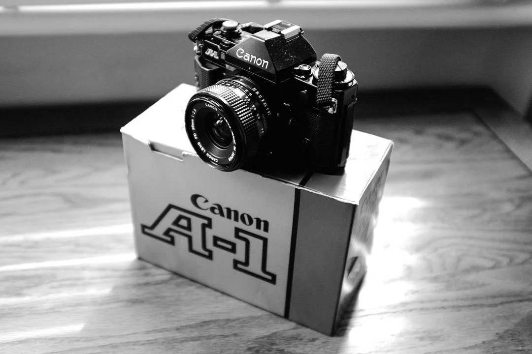 black canon a-1 film sir on table in window light.
