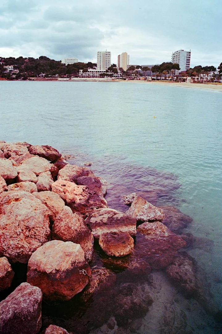 ocean with rocks in foreground during sunset, Palma Nova