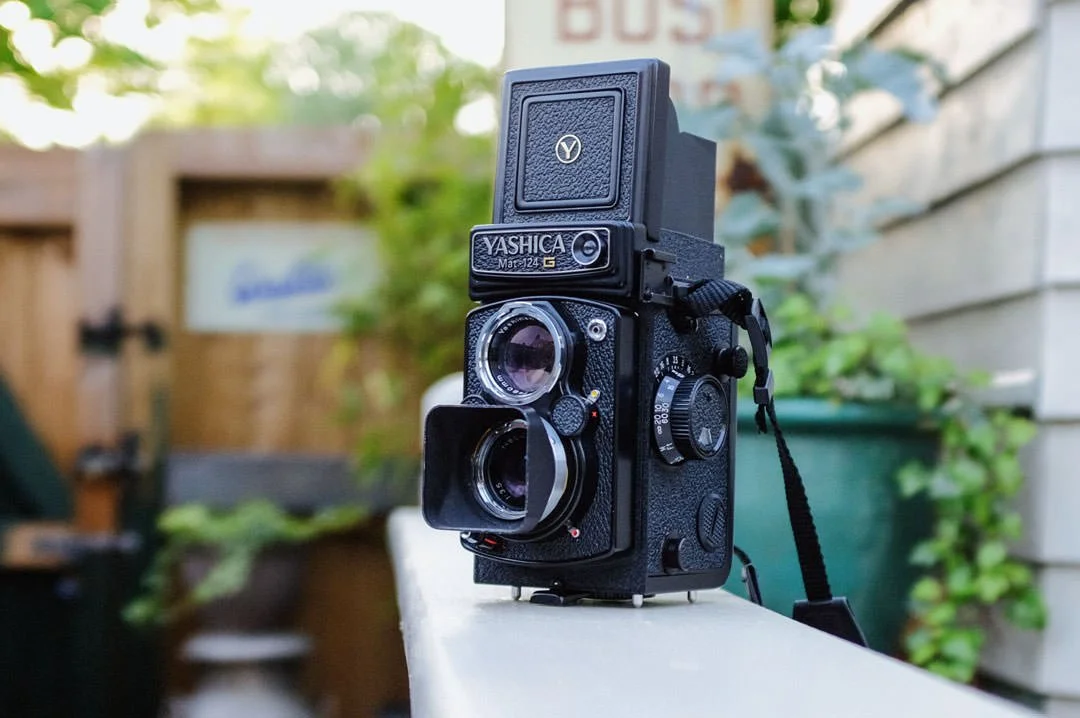 Yashica mat-124G film camera with flowers behind, photo of camera