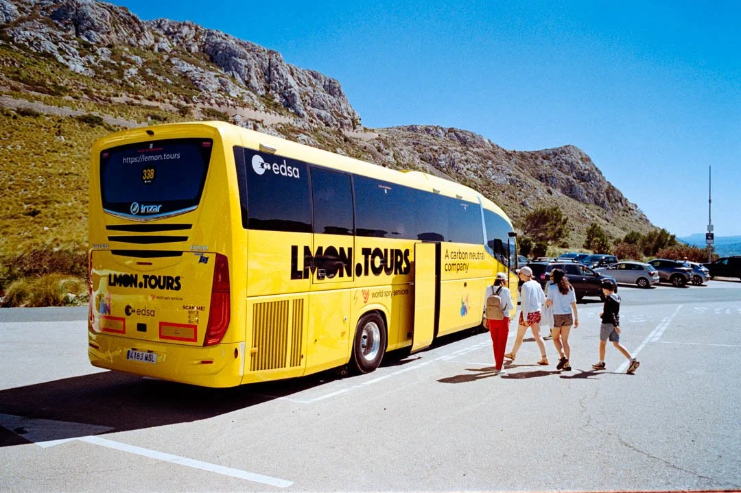 Yellow coach parked near rocky cliffs, Lemon tours majorca