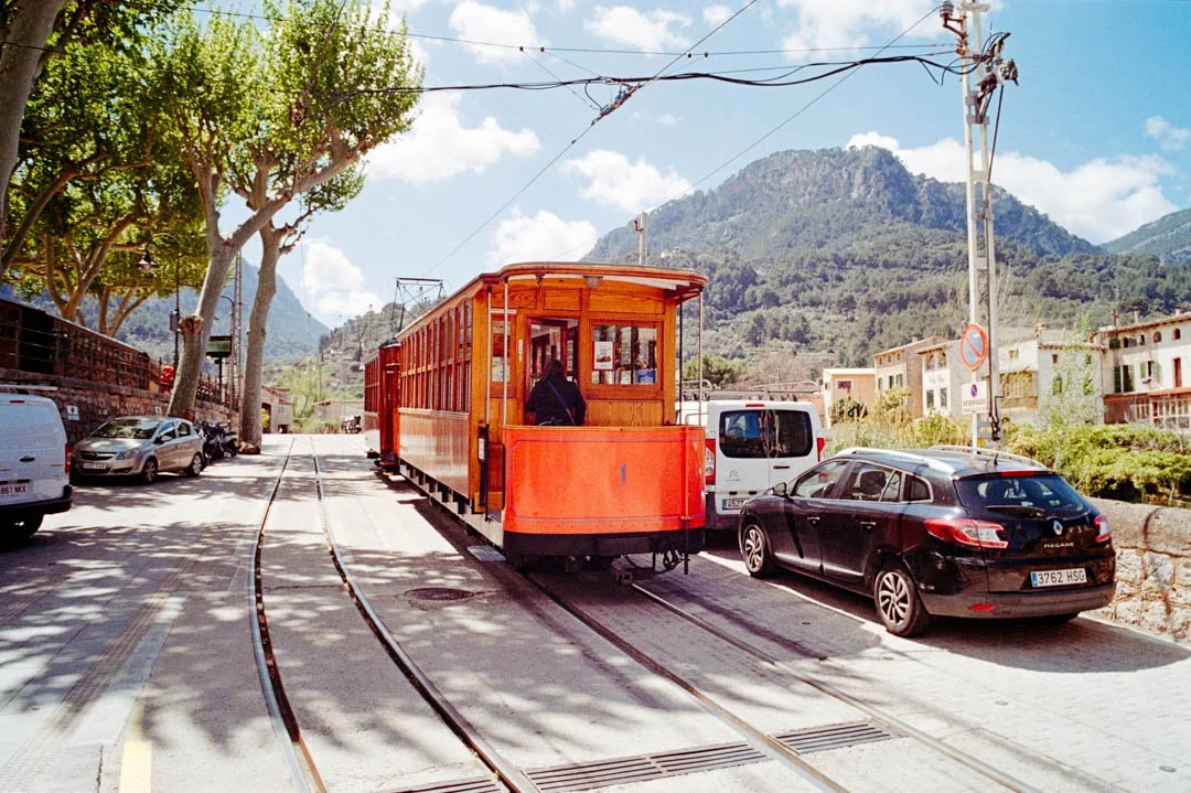 Sóller tram with mountains behind under blue sky