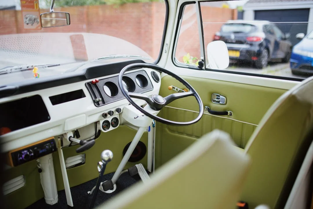 classic vw camper van steering wheel and interior. the chairs and door cards are green