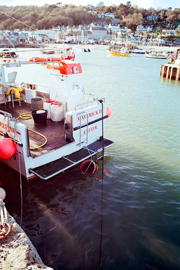 blue and white fishing boat inside small harbour, canon a-1