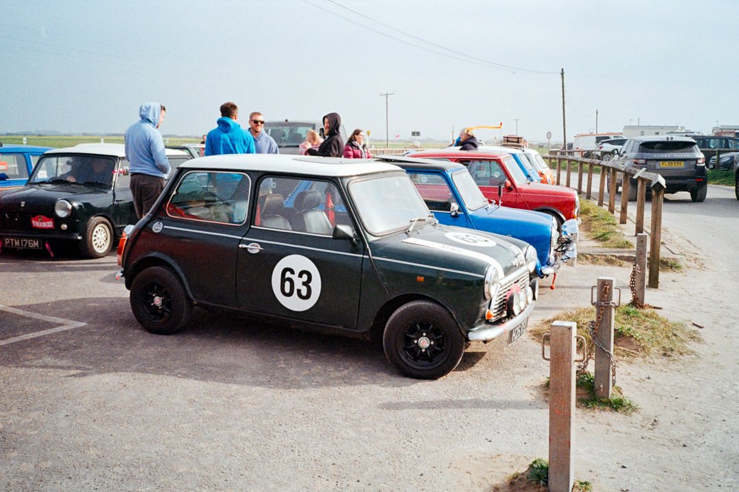 classic mini cars in all colours parked in a line