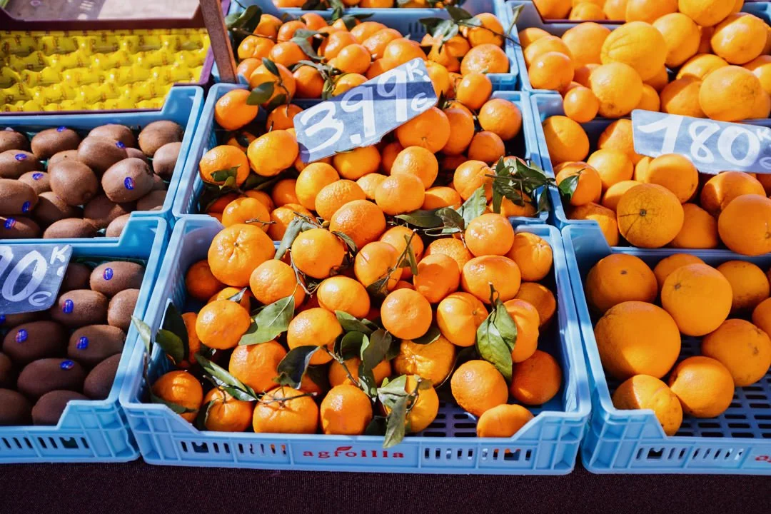 blue trays filled with oranges in sunlight at Alcudia Market