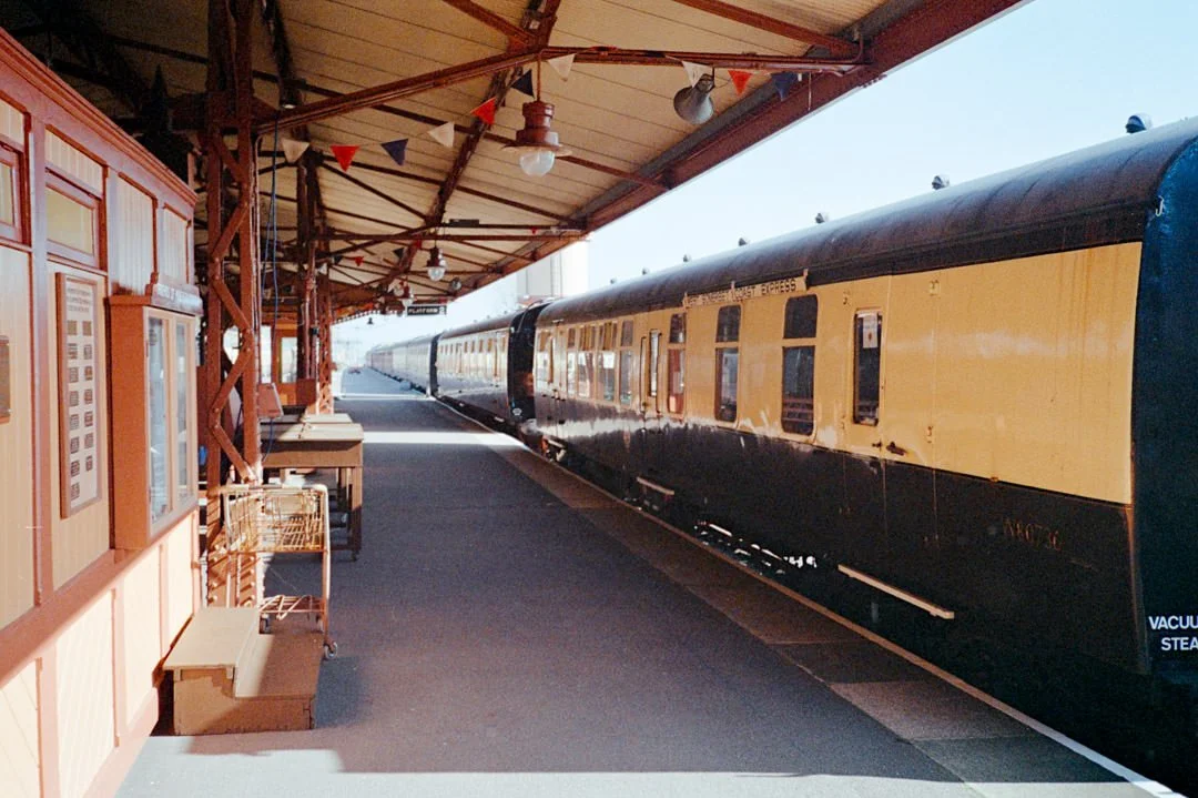 steam train carriages along station platform during sunny day