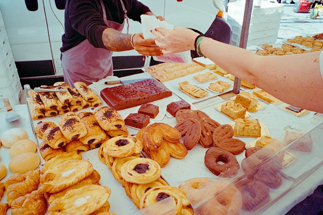 pastry foods on market stalls, cash is being exchanged