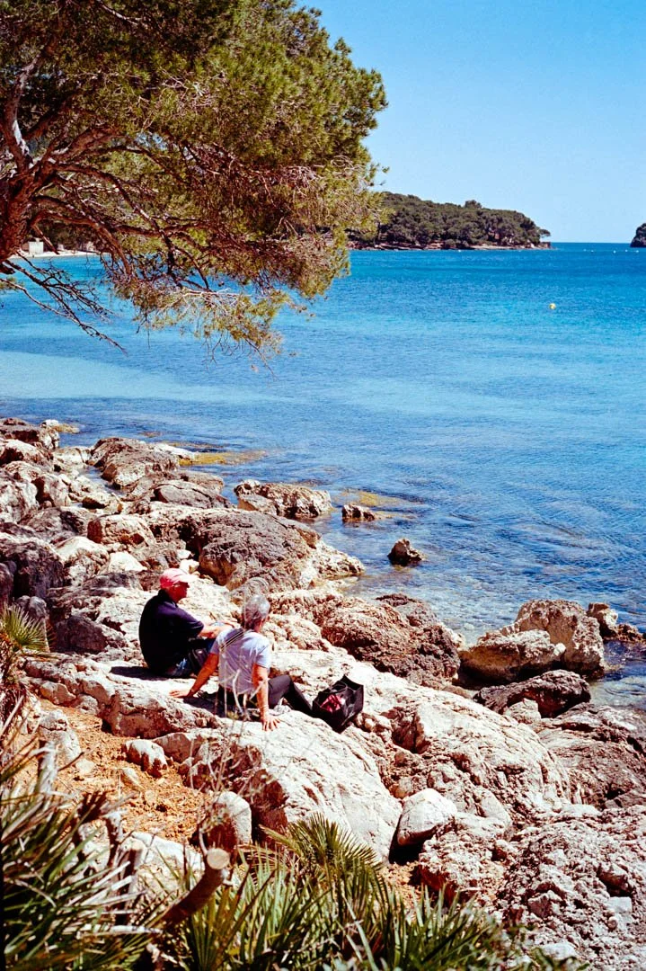 two people sat on rocks near blue ocean, Majorca Island