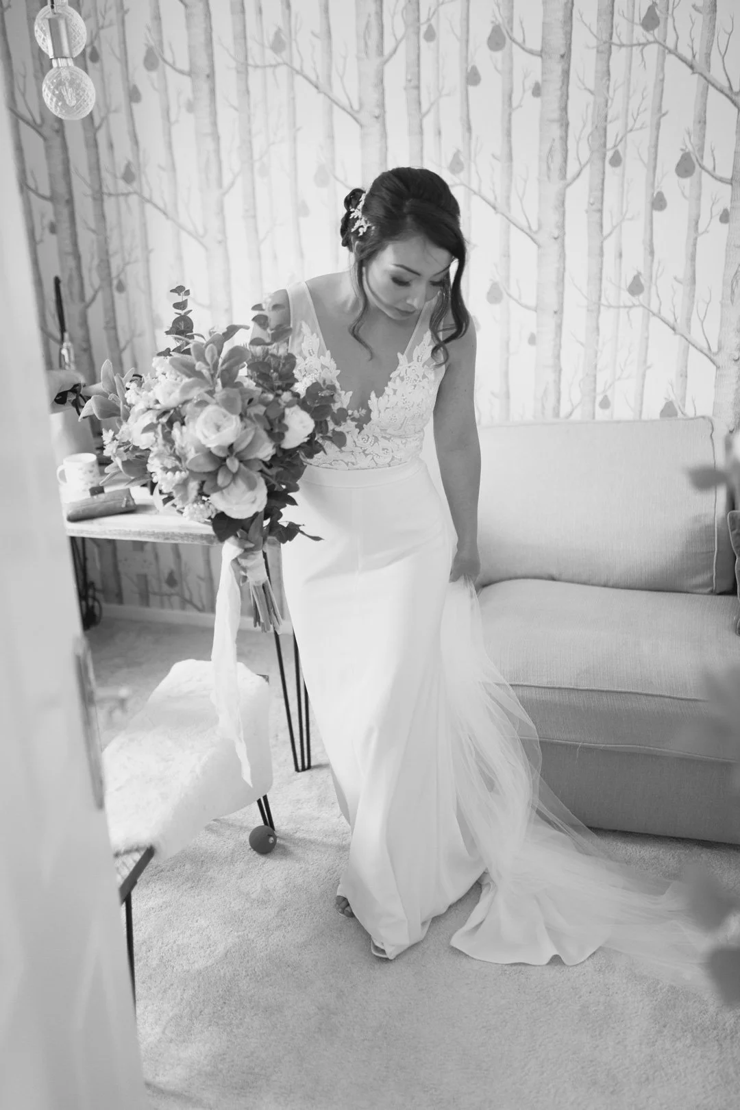 black and white photo of a wedding bride in white dress holding flowers.