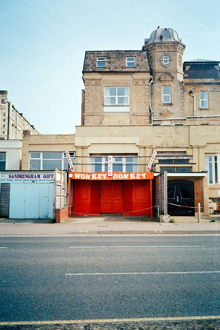 small shop with red sign above door. its says monkey donkey in large white letters