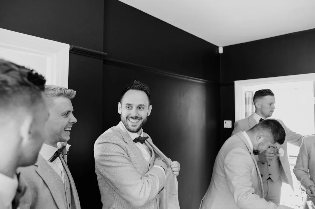 groomsmen waring grey suits smiling and laughing