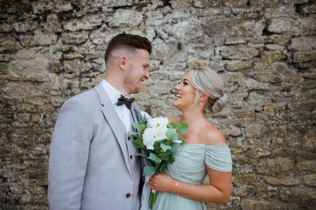 bridesmaid holding white flowers waring olive green dress