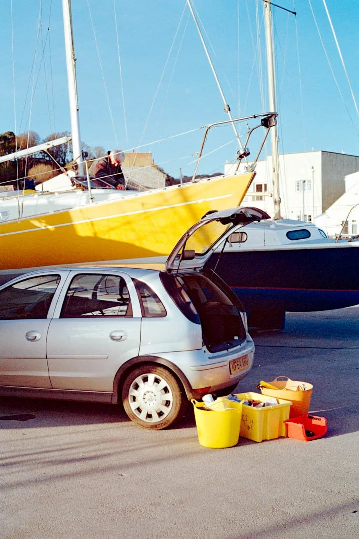 yellow yacht in dry dock with silver car infront, canon a-1