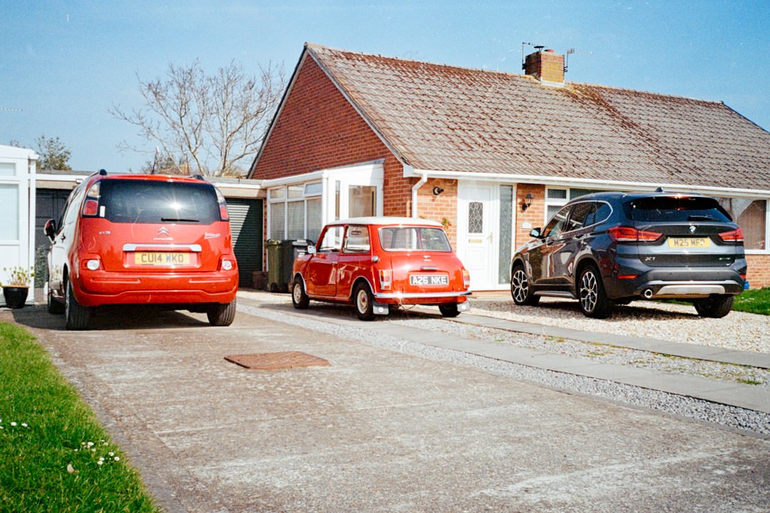 classic red mini on driveway outside bungalow house