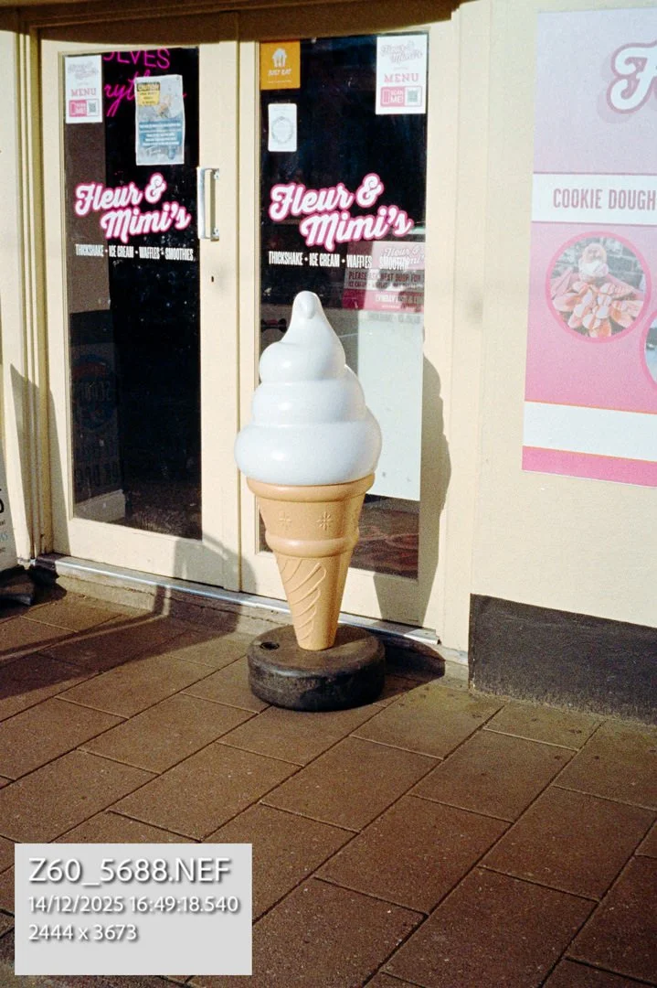 large ice cream outside of shop window in sunlight
