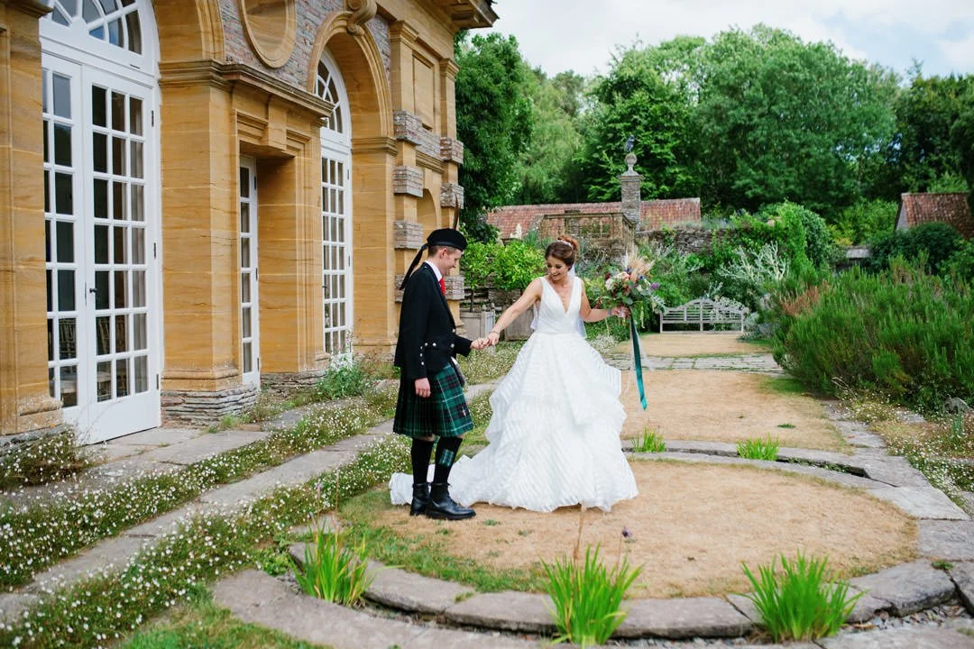 bride and groom holding hands in garden outside orangery, hestercombe house Somerset