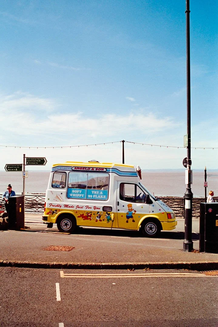 yellow and white ice cream van with ocean behind, canon a-1