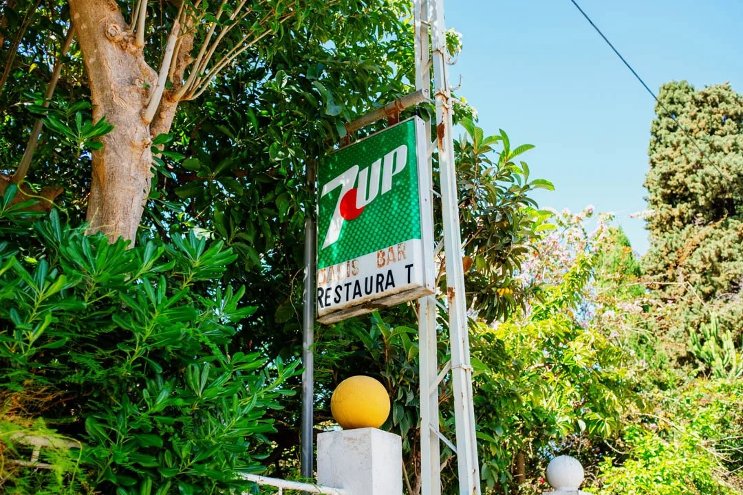vintage 7up street sign under large tree in sunshine