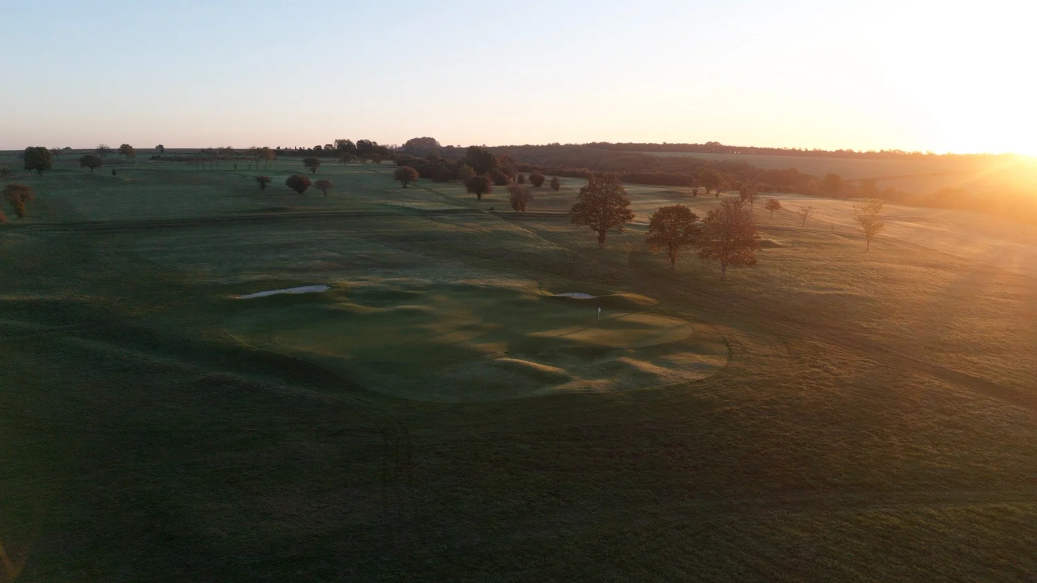 Low evening sun over a green at Hockley Golf Club