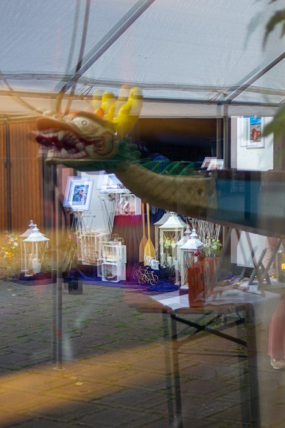 Reflexion einer Trauerzeremonie bei Sonnenuntergang mit einem Dekor-Drachen an der Fensterscheibe.