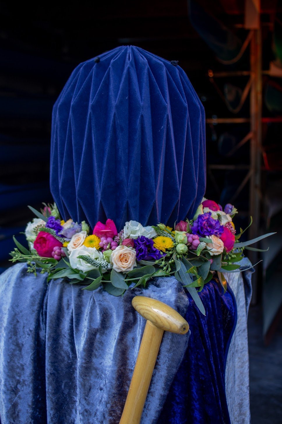 Ein Sarg, bedeckt mit blauen Samt, ist mit einem bunten Blumenkranz aus Rosen, Nelken, Limoncello, Eukalyptus und Borretsch verziert.