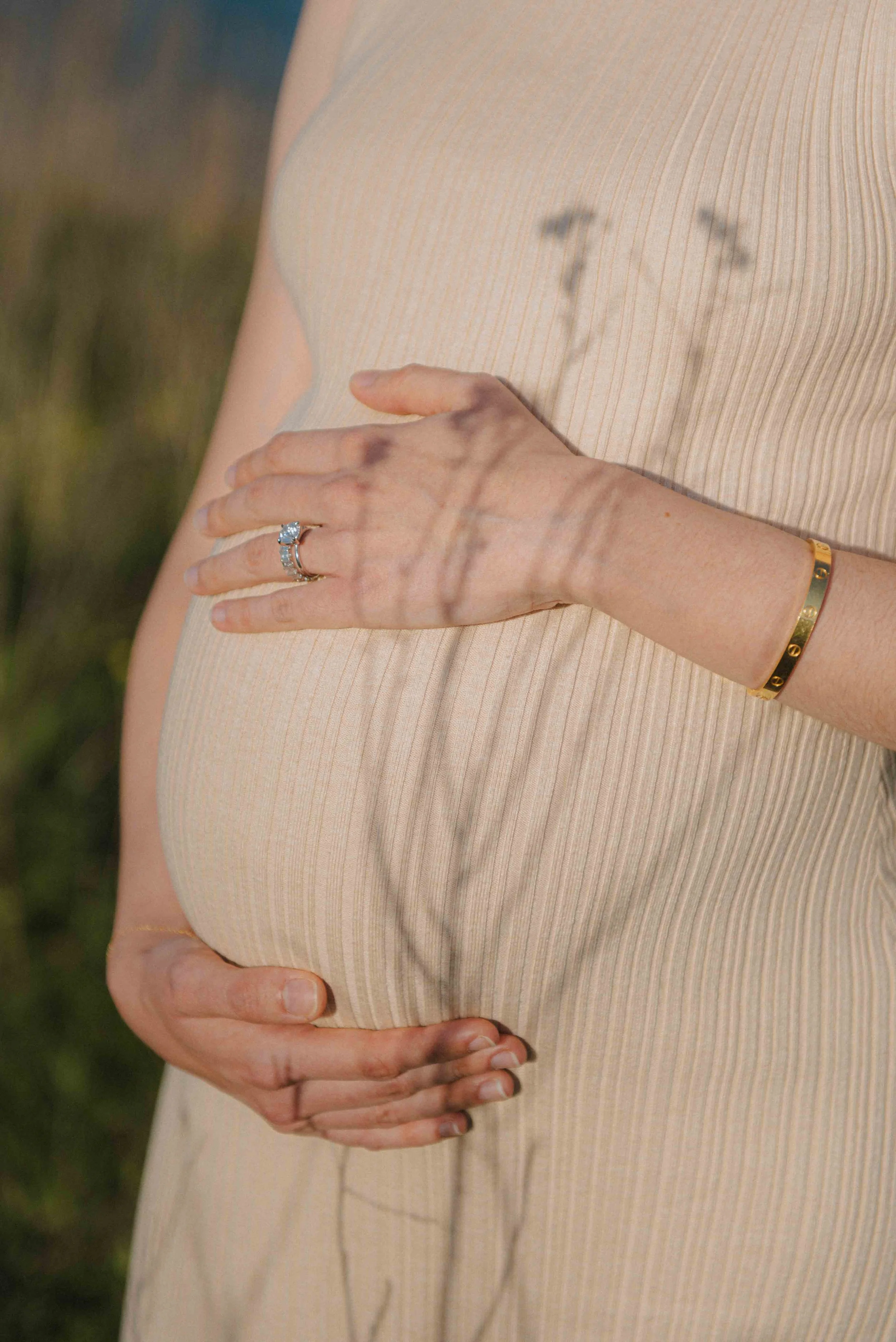 babybauch-detailaufnahme-ring-hand-sonnenlicht.jpg