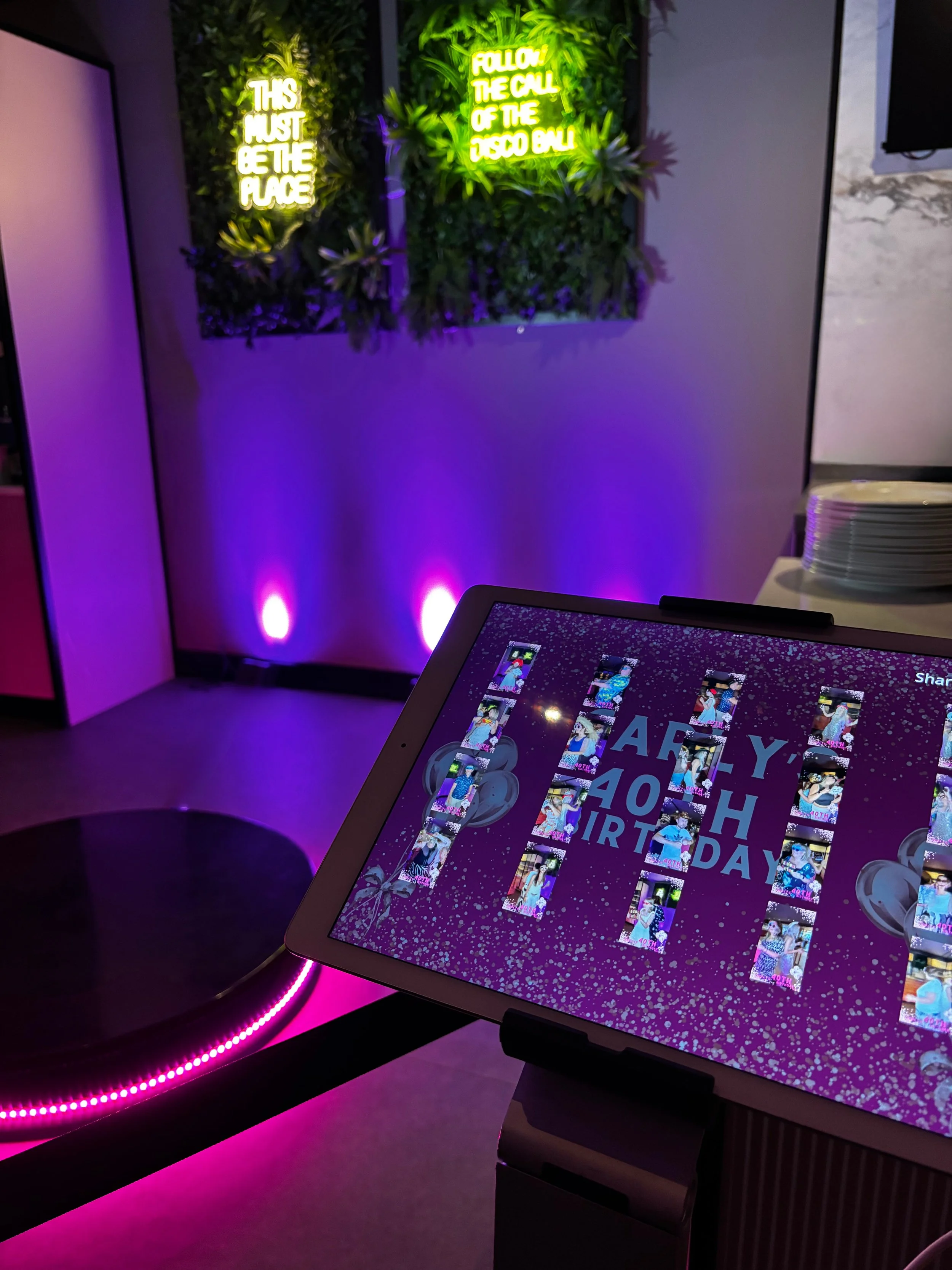 A digital sharing station screen displaying videos captured on a 360 video booth. 360 video booth with neon pink led lighting