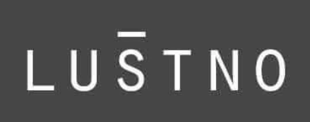 Close-up of a logo with the text 'LUST NO' on a dark background.