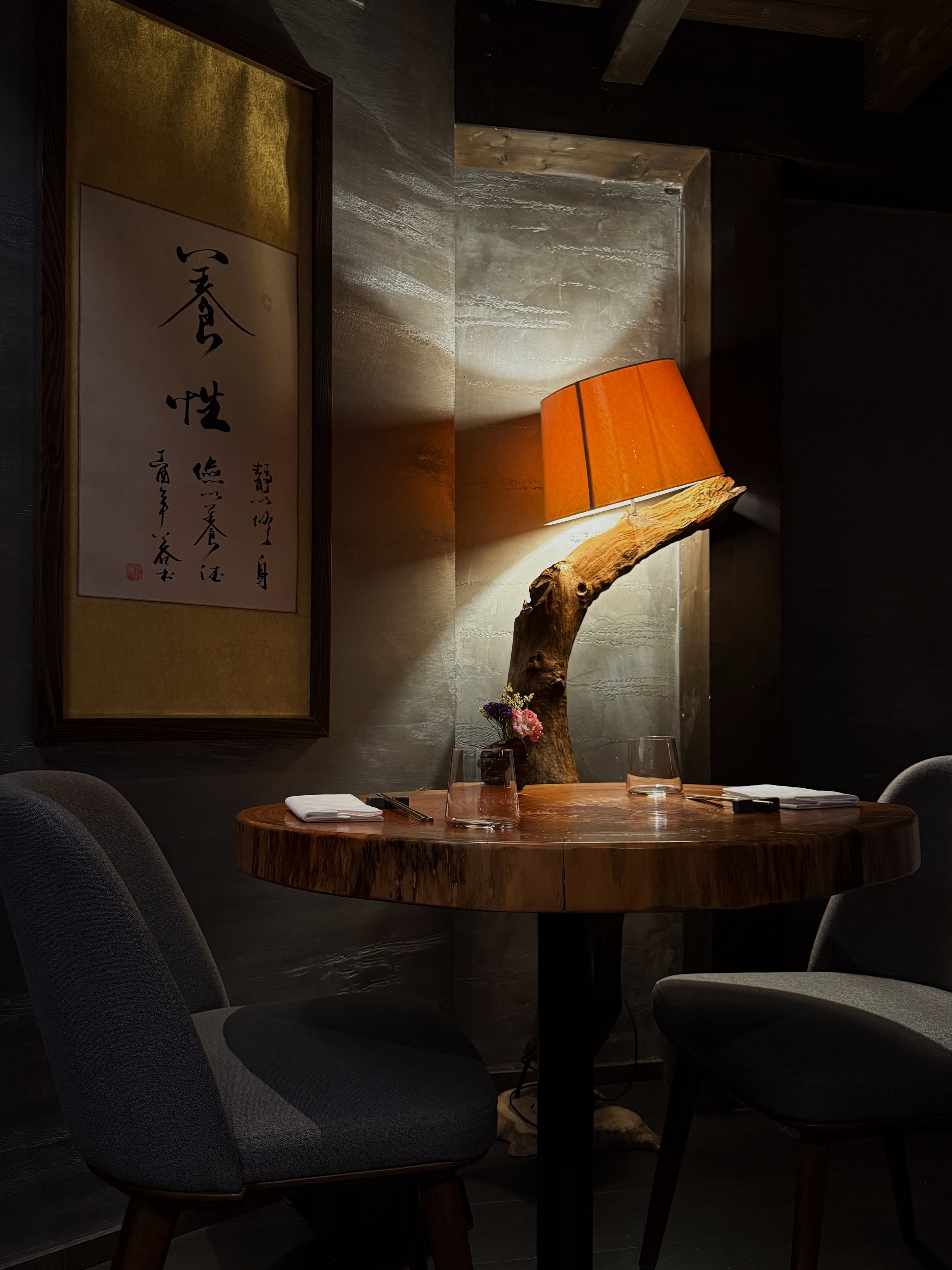 Atmospheric dining interior at MU Dimsum in Milan, showcasing contemporary hospitality design and warm architectural lighting.