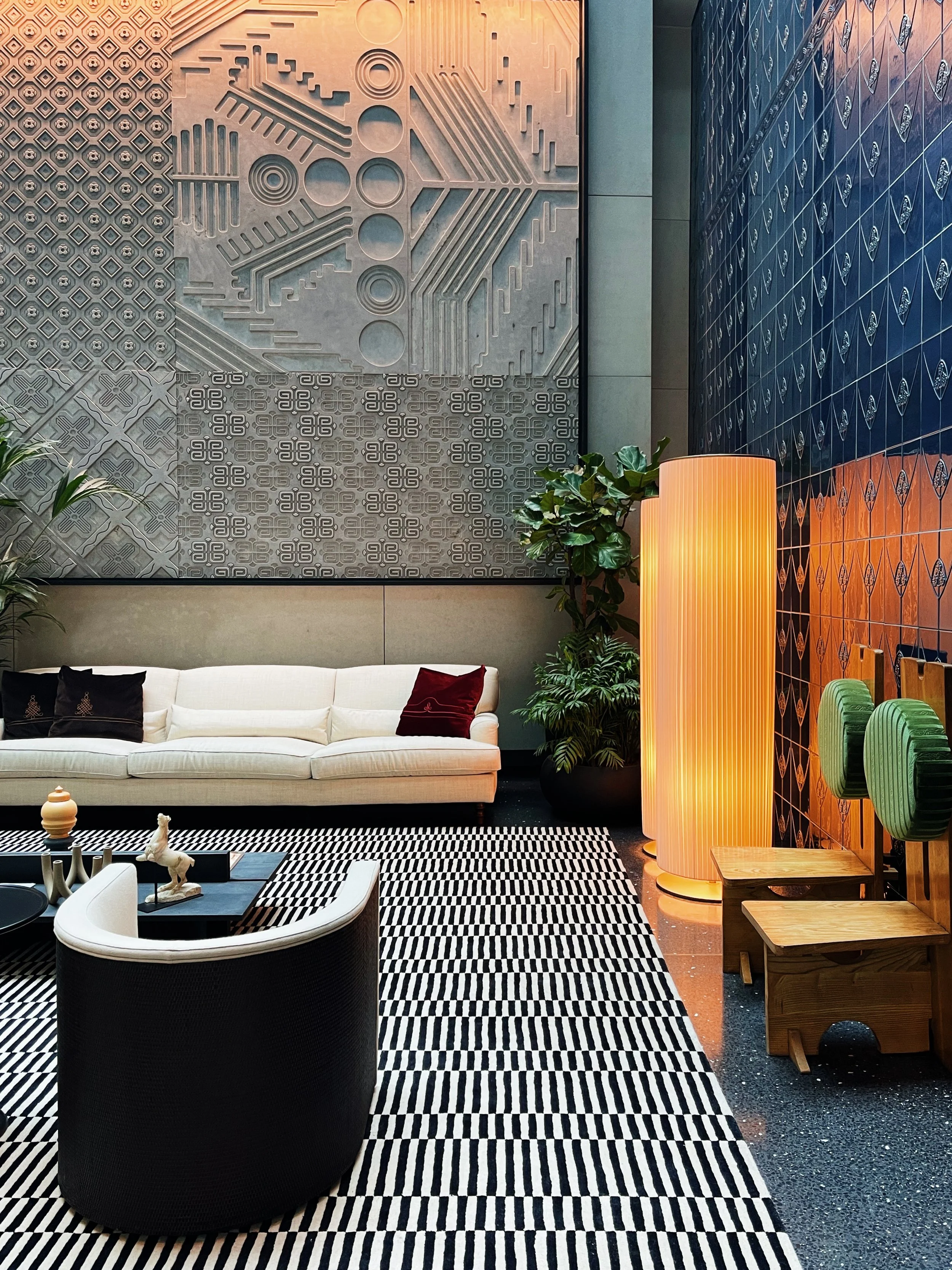 Lounge area at Dorothea Hotel Budapest with blue tiled backdrop and layered textile textures photographed by hospitality photographer Natalia Moreno.