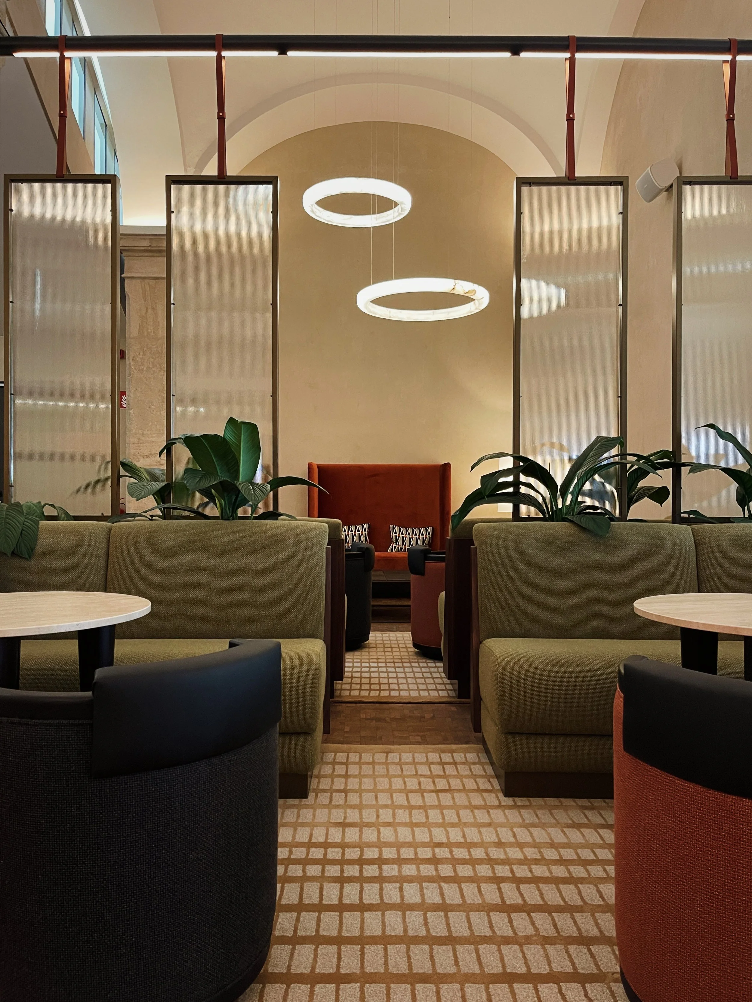 Dining booth seating at Riding School Vienna hotel with curved architectural forms, soft lighting, and contemporary hospitality design