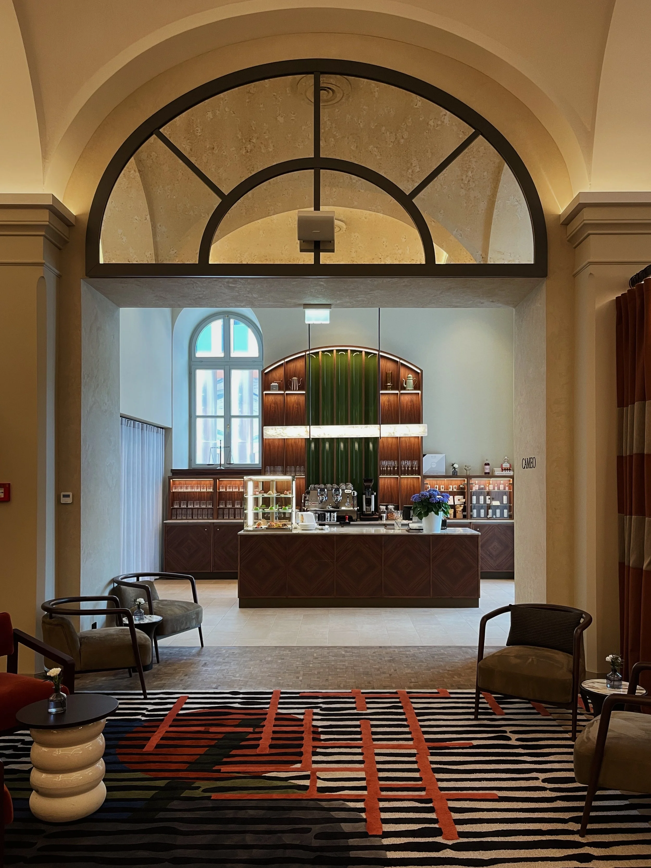 Hotel bar interior at Riding School Vienna featuring arched architecture, warm lighting, and refined material detailing in a luxury hospitality setting