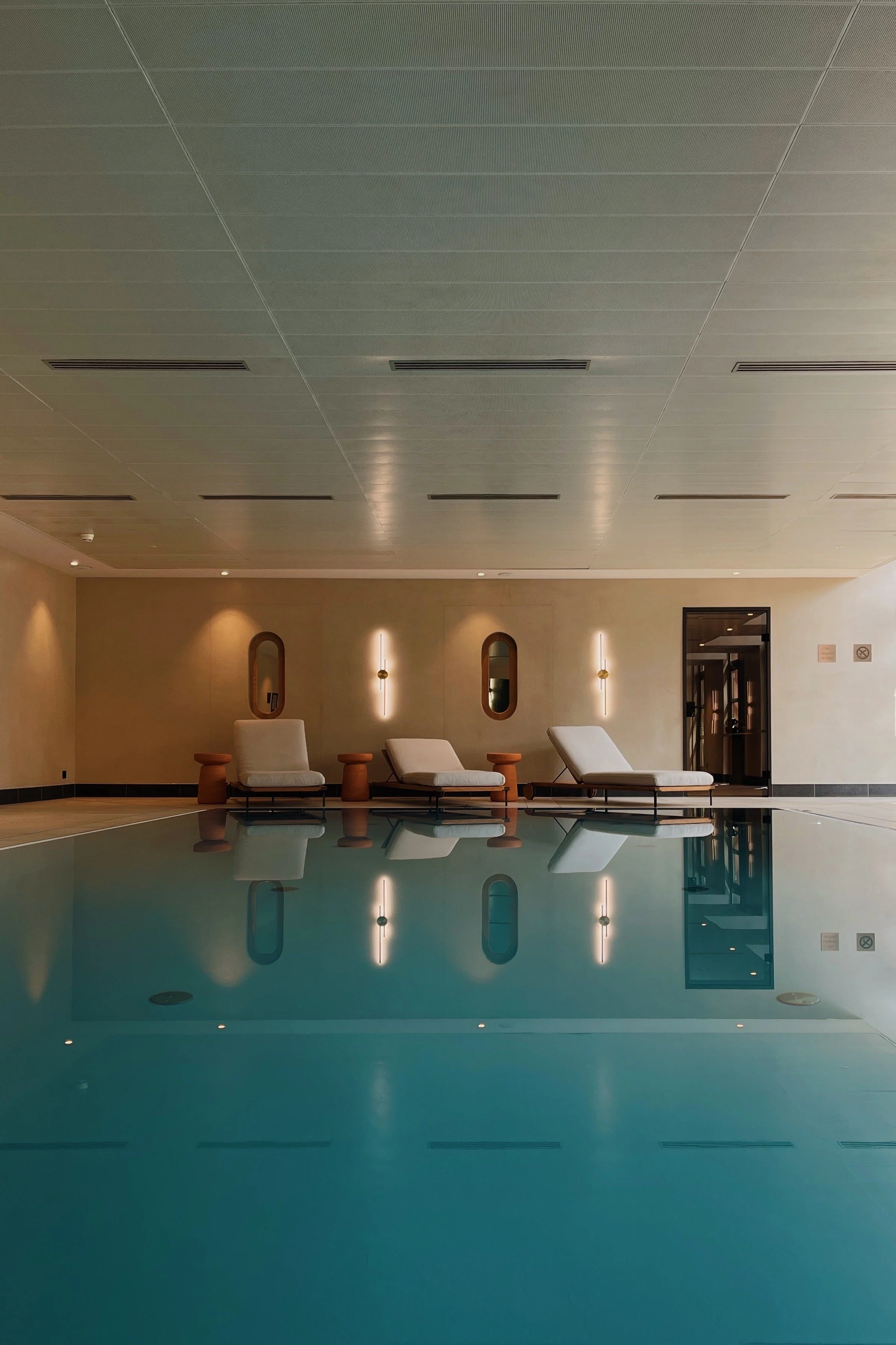 Indoor swimming pool at Riding School Vienna with vaulted ceilings and serene spa atmosphere, photographed with an architectural hospitality perspective
