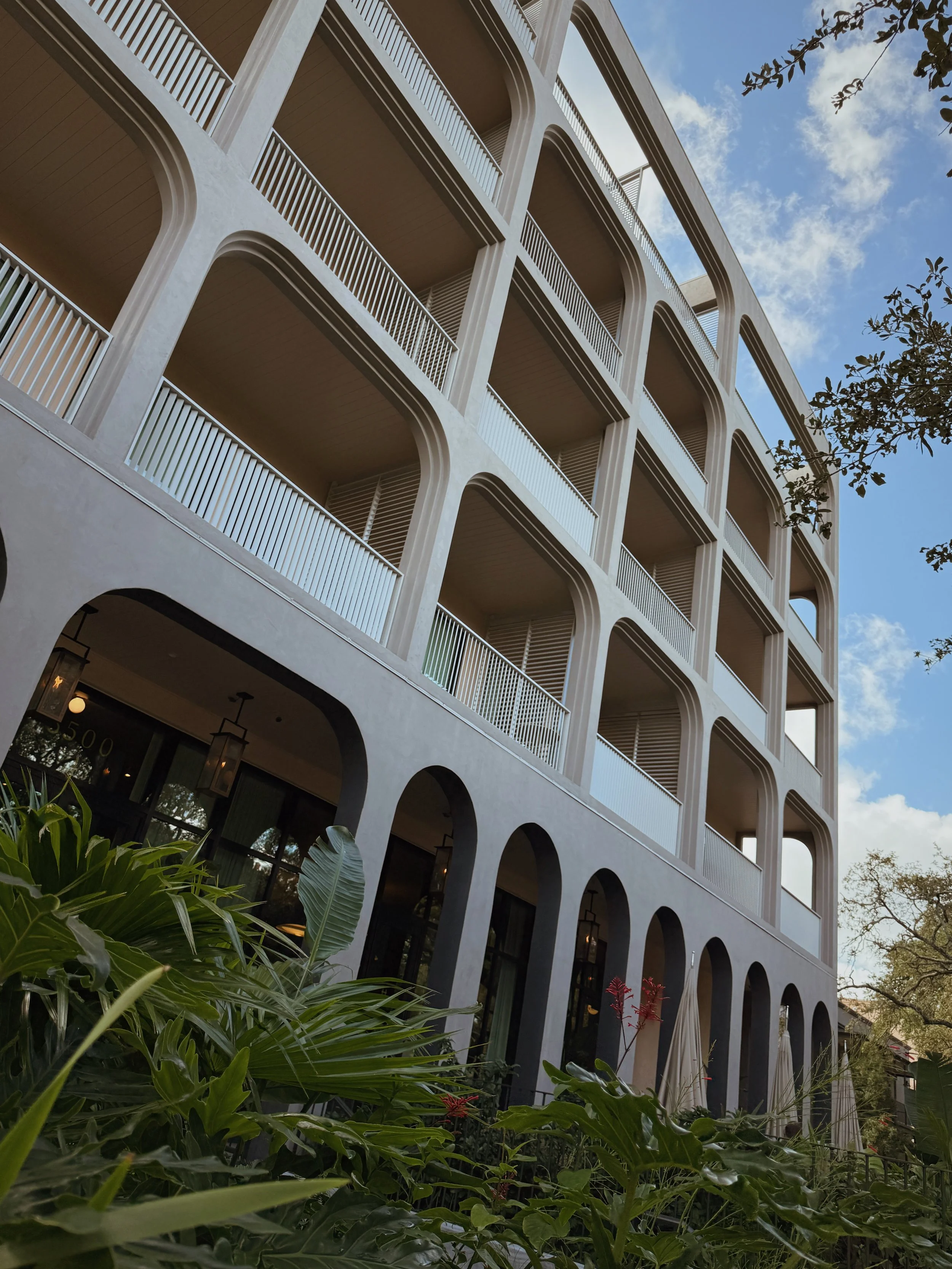 Architectural facade of Hotel Henrietta in New Orleans with rhythmic balconies and arched detailing photographed by Berlin-based hospitality photographer Natalia Moreno.