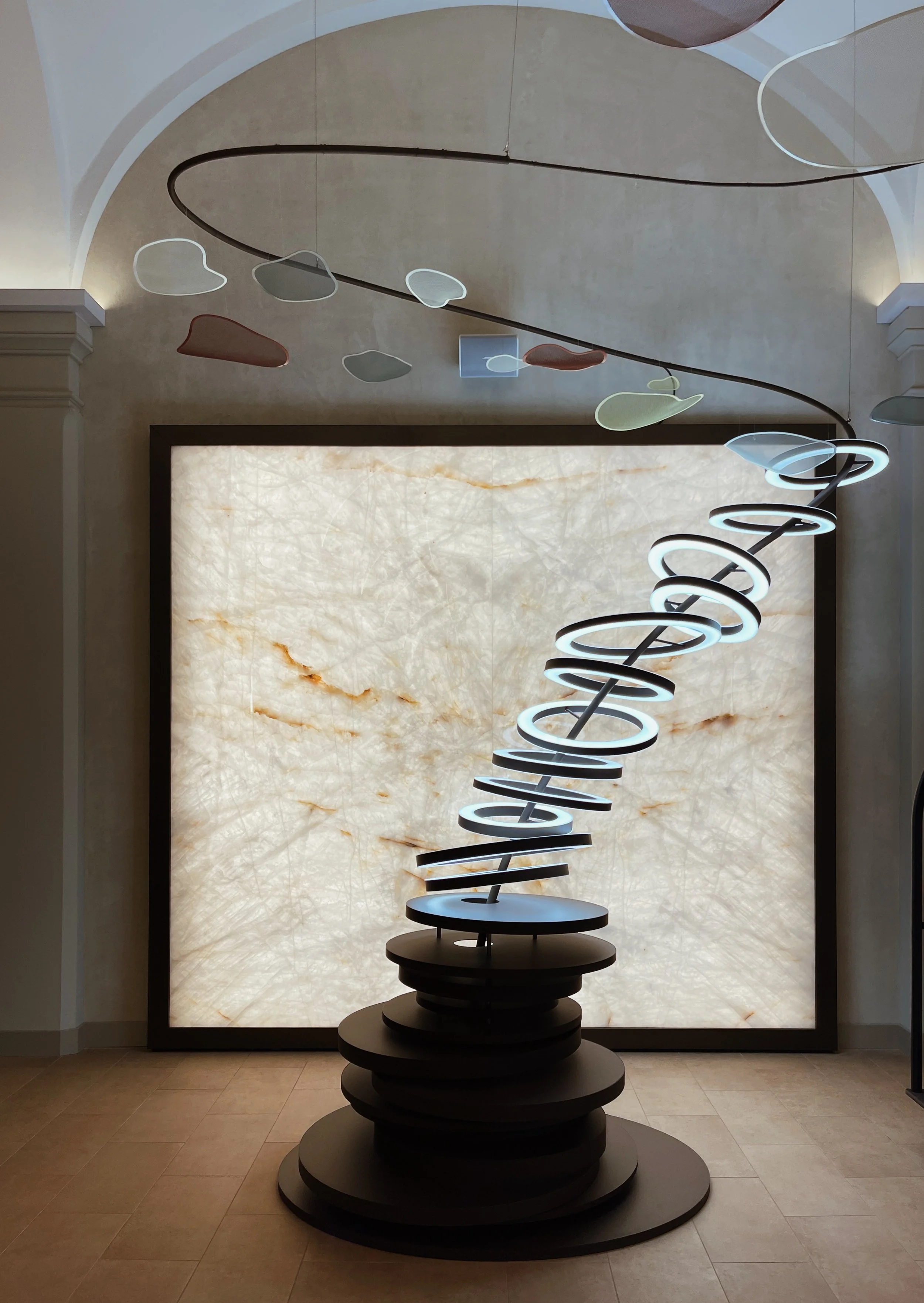 Luxury hotel lobby at Riding School Vienna featuring a contemporary art installation and sculptural stone backdrop, captured with an architectural hospitality photography approach