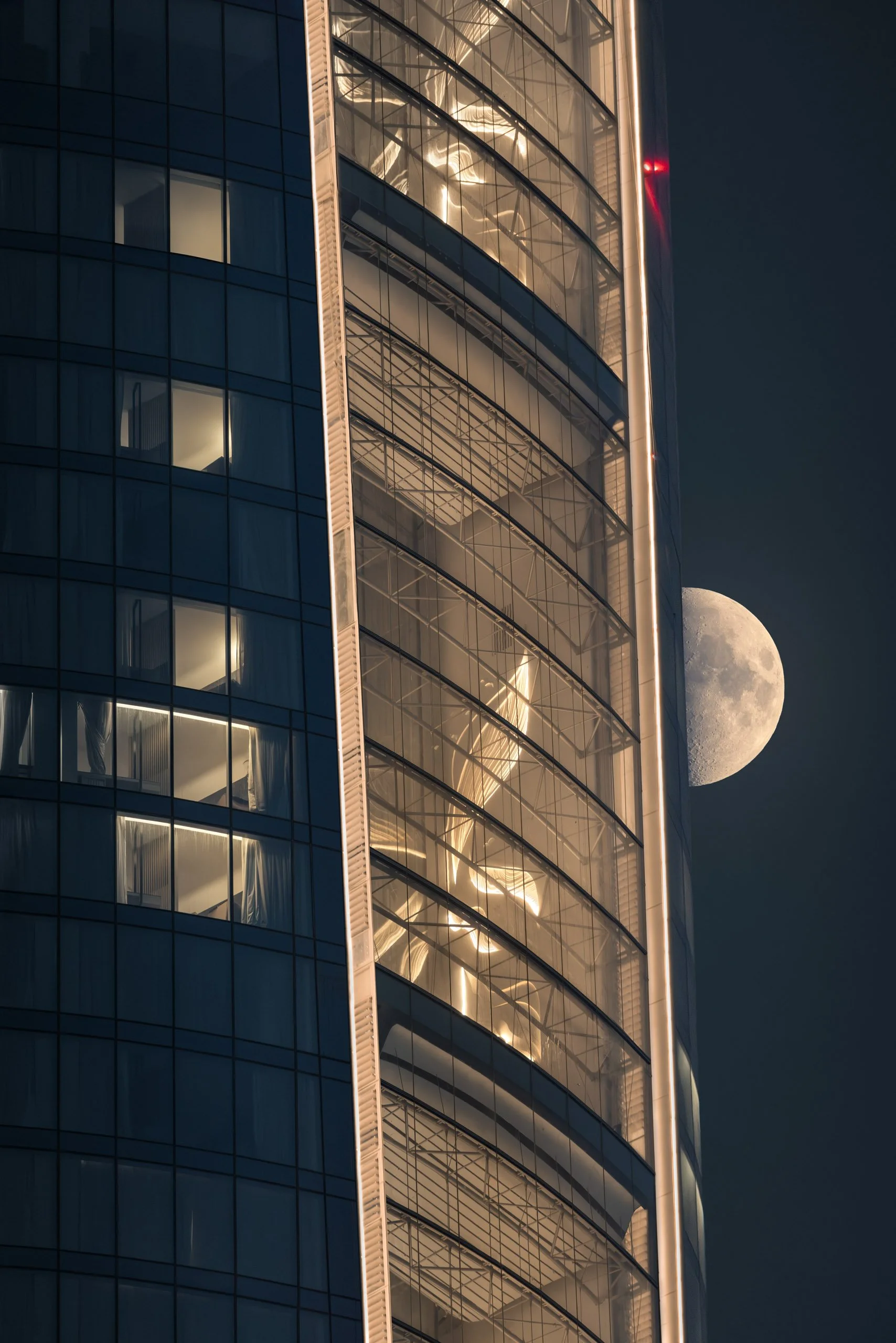 A waxing moon beside Ciel's curved glass facade