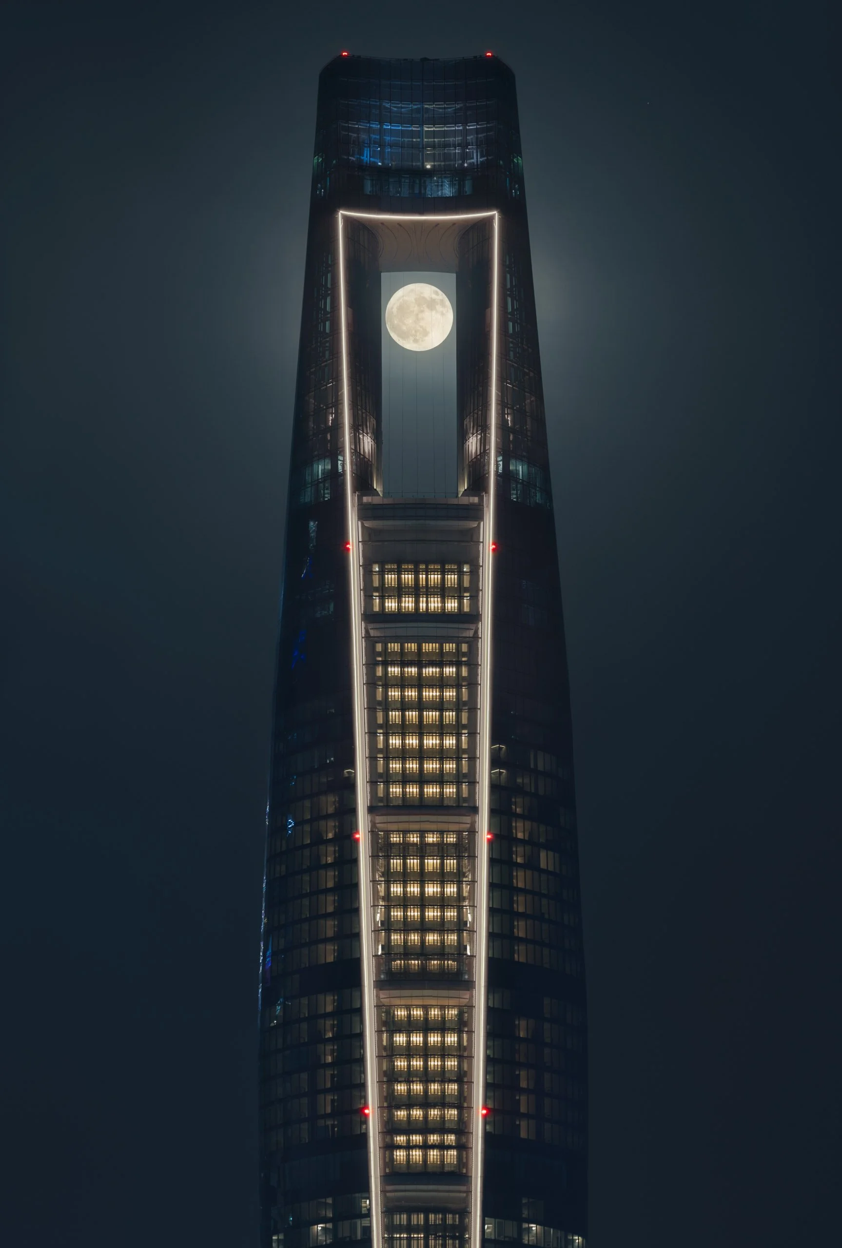 The full moon framed inside the aperture near the top of Ciel Dubai Marina at night.